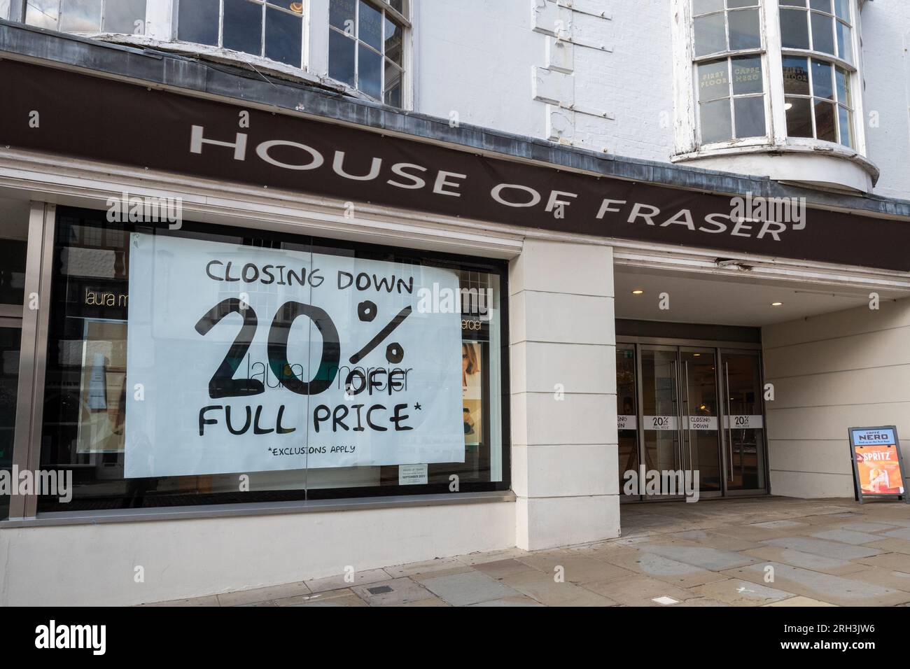 Das Kaufhaus House of Fraser in Guildford, Surrey, England, wird am 30. 2023. September geschlossen. Auf dem Foto vom 13. 2023. August wird auf großen Plakaten in den Schaufenstern des Ladengeschäfts mit einem Rabatt von 20 % beim Abschluss des Verkaufsangebots geworben. Stockfoto