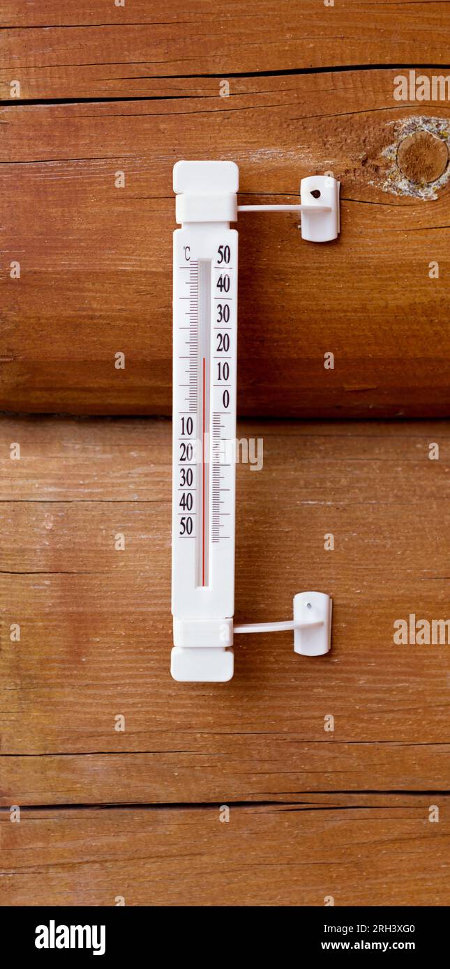 Thermometer an der Wand eines Holzhauses. Wetterthermometer in Grad celsius. Stockfoto