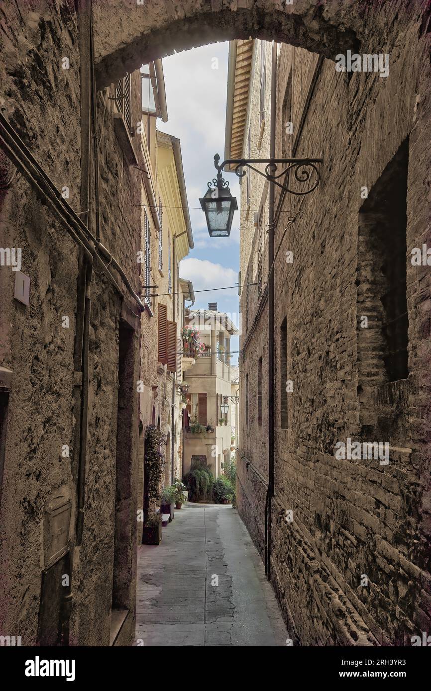 Bevagna, Umbrien, Italien. Eine Gasse, gesäumt von alten Häusern mit Stein- und Ziegelwänden in der mittelalterlichen Altstadt. Stockfoto