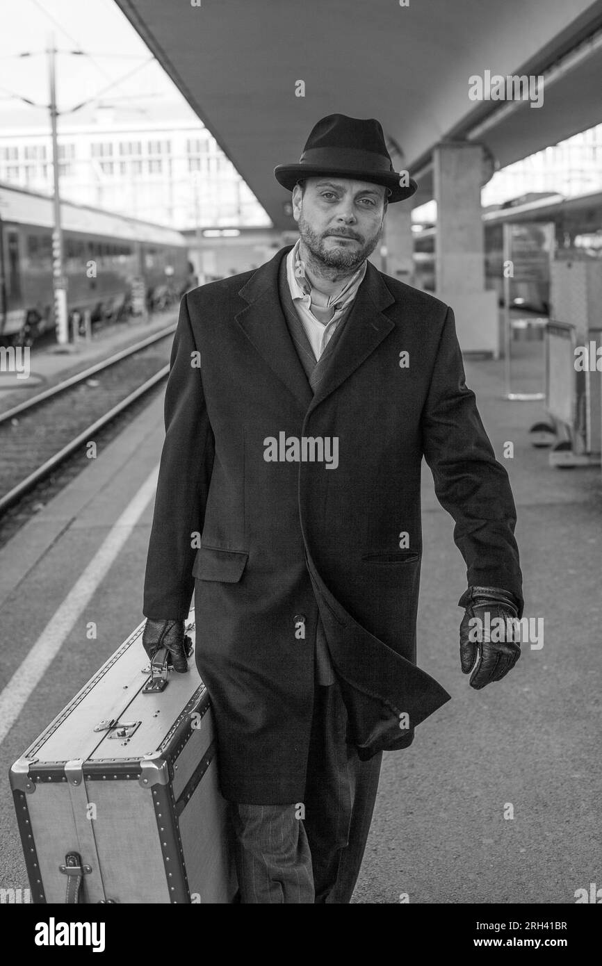 Ein Mann mit Koffer geht auf den Bahnsteig Stockfoto