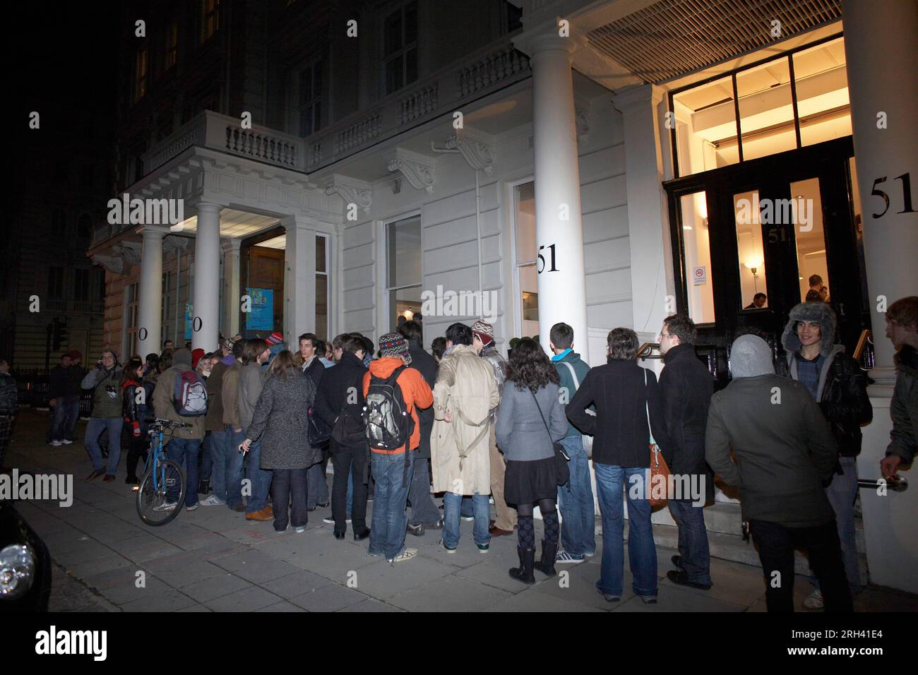 Leute, die in einer einzigen Linie vor einem Gebäude in London stehen. Stockfoto