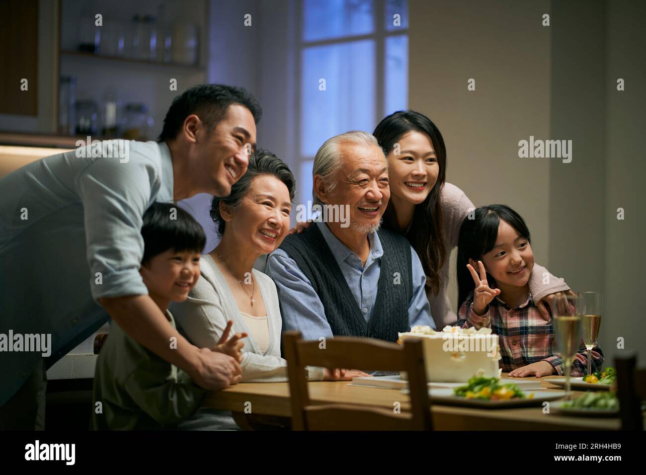 Eine asiatische Familie aus drei Generationen zu Hause, um den Hochzeitstag des Seniorenpaares zu feiern Stockfoto