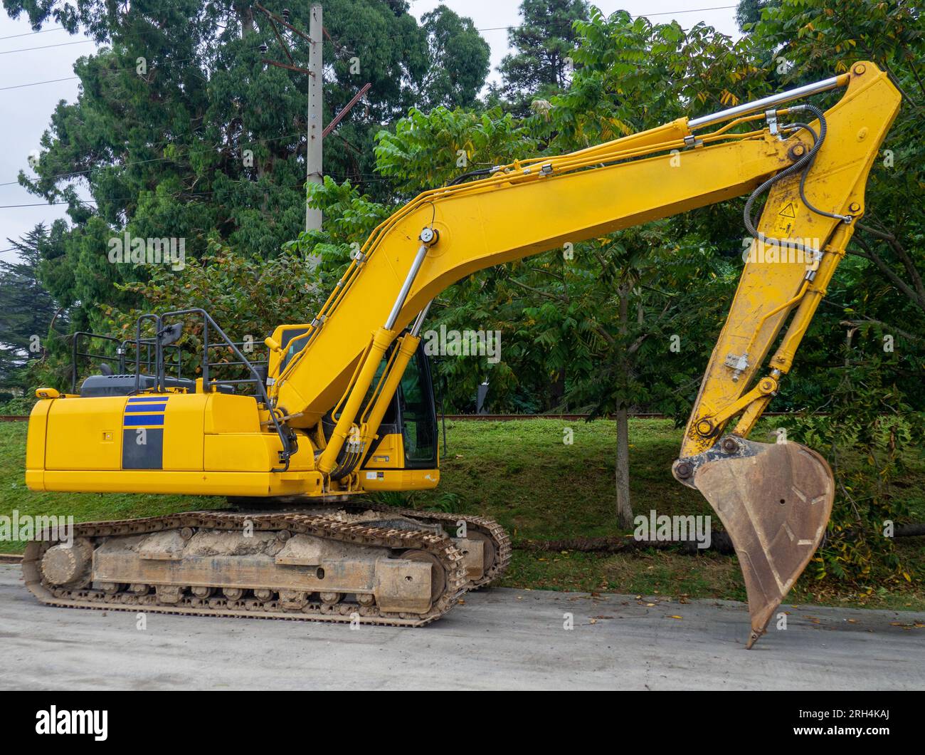 Schwere Baumaschinen auf dem Parkplatz. Löffelbagger. Gelbes schweres Auto. Baumaschinen. Arbeitslos. Ohne Fahrer Stockfoto