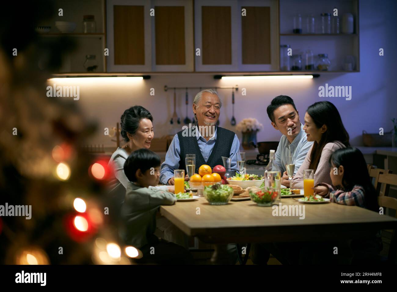 Eine asiatische Familie aus drei Generationen, die zu Hause zu weihnachten zu Abend isst Stockfoto