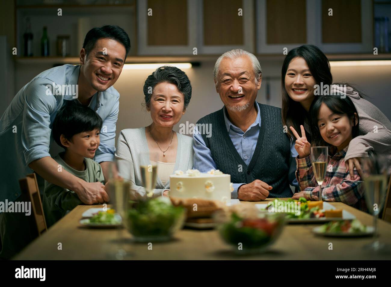 Eine asiatische Familie aus drei Generationen zu Hause, um den Hochzeitstag des Seniorenpaares zu feiern Stockfoto