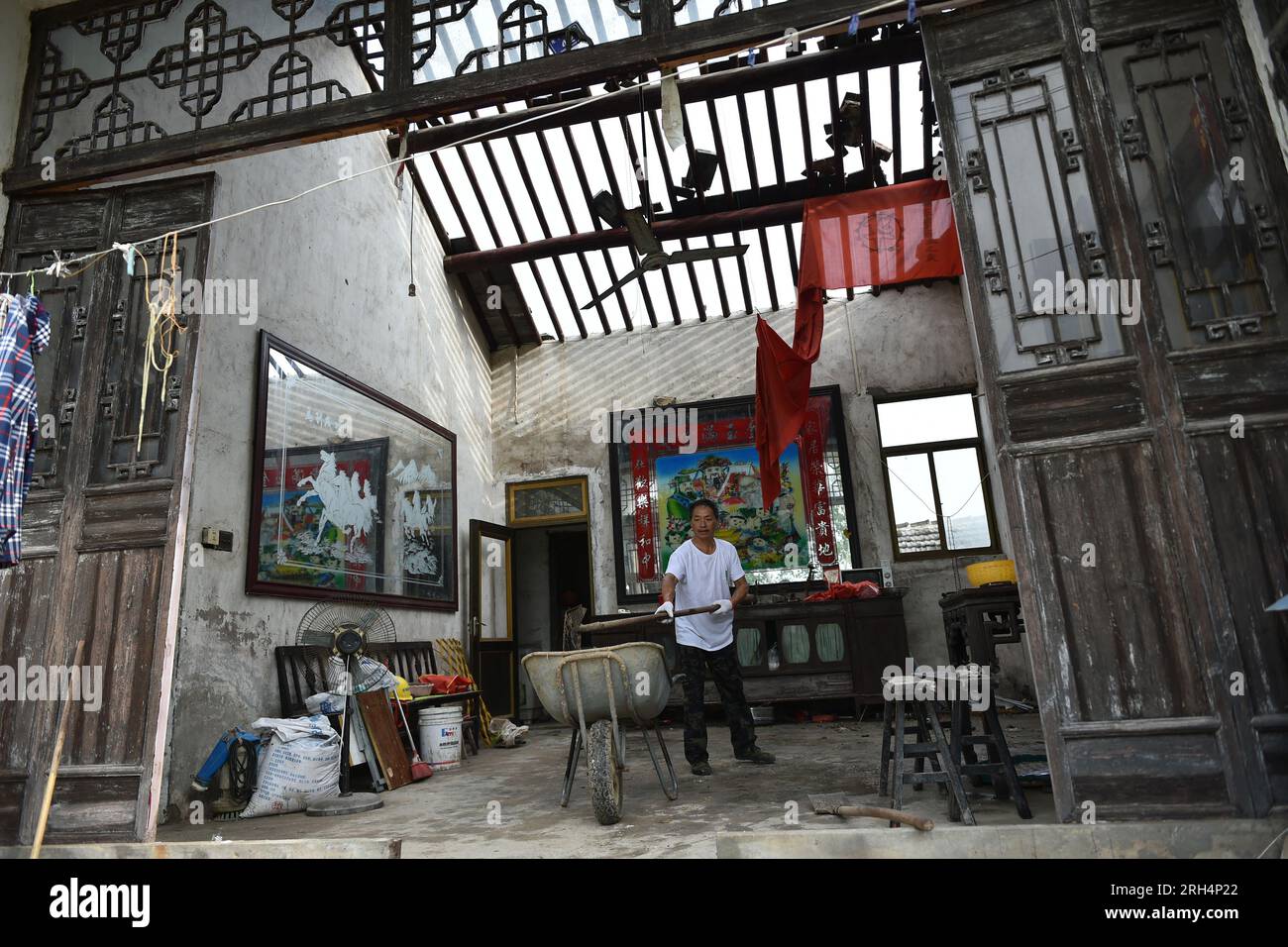 YANCHENG, CHINA - 14. AUGUST 2023 - Ein Bürger räumt ein beschädigtes Haus nach einem Tornado im Bezirk Dafeng, Stadt Yancheng, Provinz Jiangsu, China, Australien auf Stockfoto
