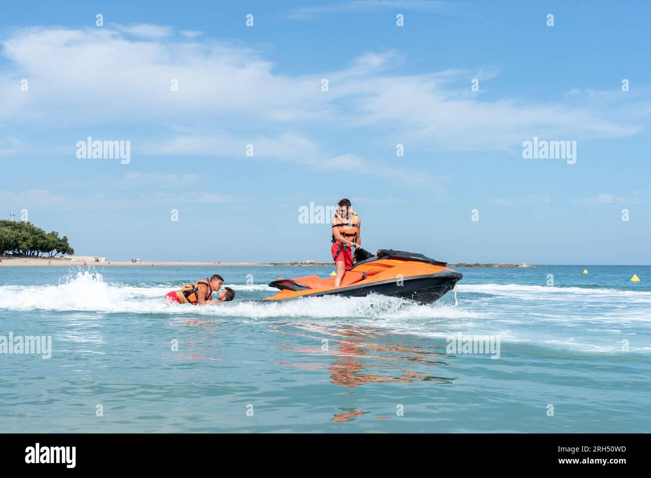 Profilfoto eines Rettungsschwimmers, der einen Jet-Ski auf dem Meer fährt Stockfoto