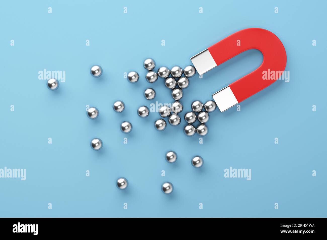 Metallkugeln, die zu einem roten Magneten auf blauem Hintergrund eingeprägt sind. Digitales Marketing, Führungsposition, Kundengewinnung und Follower in sozialen Medien Stockfoto