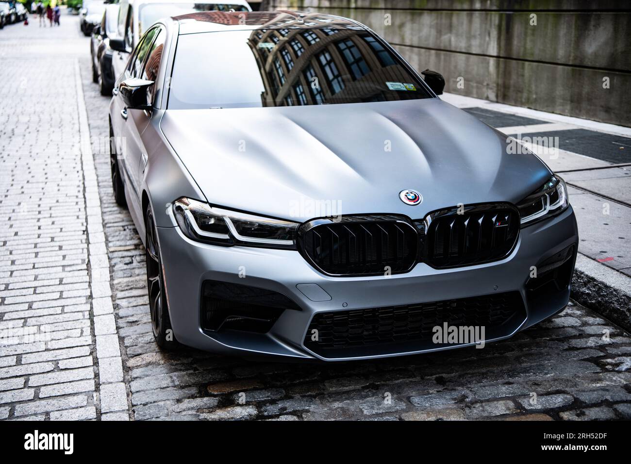 New York City, USA - 15. Juli 2023: Grauer BMW F90 M5-Wagen geparkt, Eckansicht Stockfoto