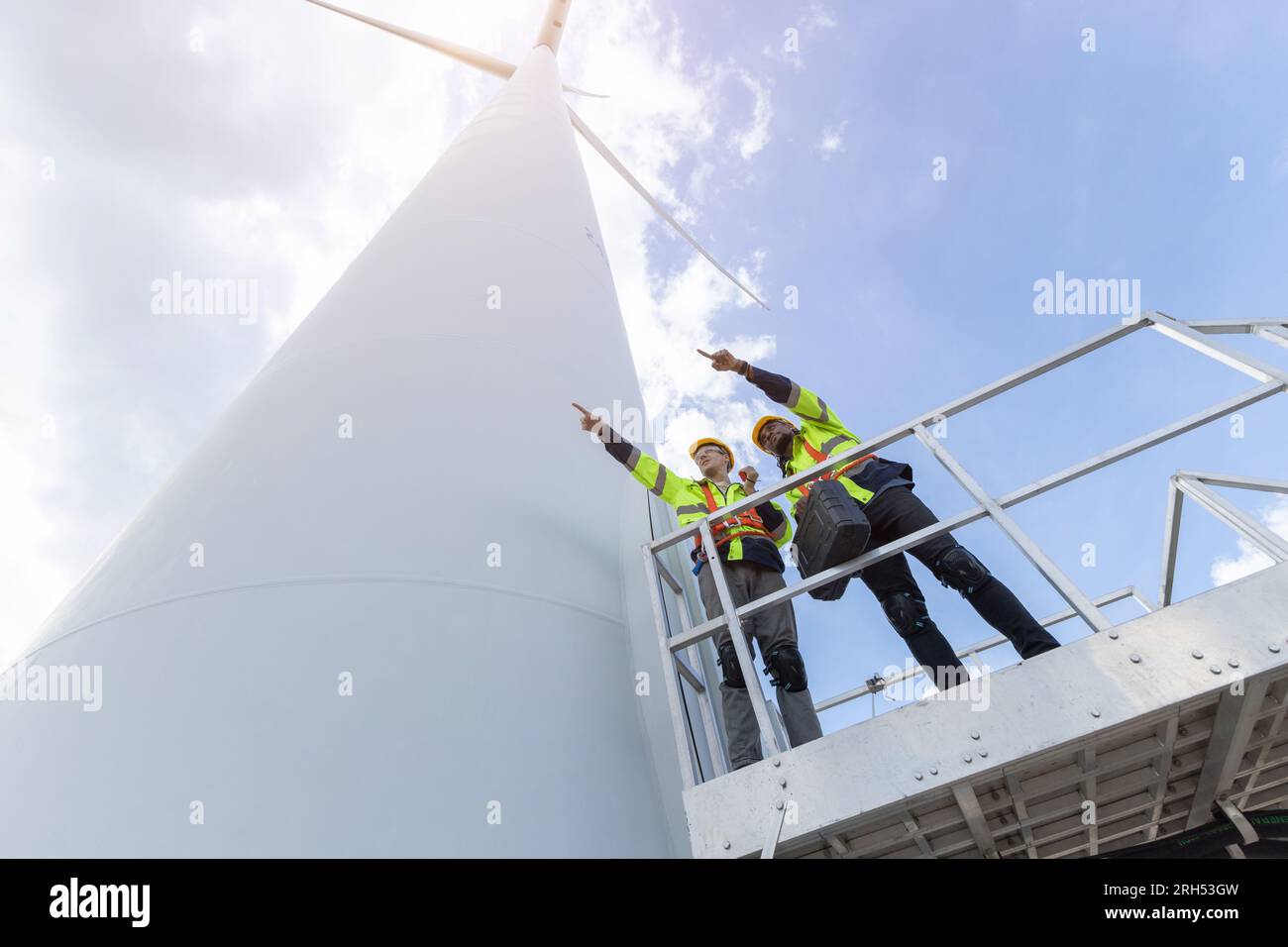 Techniker für Windturbinenanlagen, männliches Team, das für die Instandhaltung der Baustelle zuständig ist. Eco Power-Energieerzeuger für nachhaltige Menschen Stockfoto