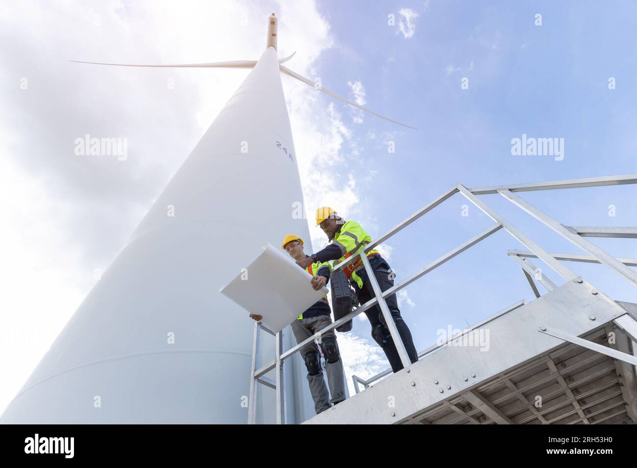 Techniker für Windturbinenanlagen, männliches Team, das für die Instandhaltung der Baustelle zuständig ist. Eco Power-Energieerzeuger für nachhaltige Menschen Stockfoto