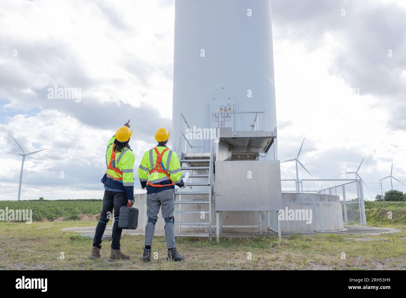 Techniker für Windturbinenanlagen, männliches Team, das für die Instandhaltung der Baustelle zuständig ist. Eco Power-Energieerzeuger für nachhaltige Menschen Stockfoto