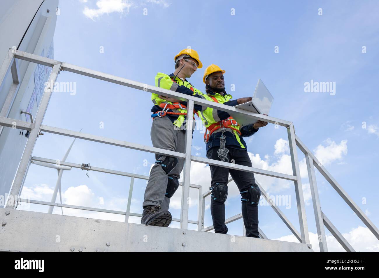 Techniker für Windturbinenanlagen, männliches Team, das für die Instandhaltung der Baustelle zuständig ist. Eco Power-Energieerzeuger für nachhaltige Menschen Stockfoto