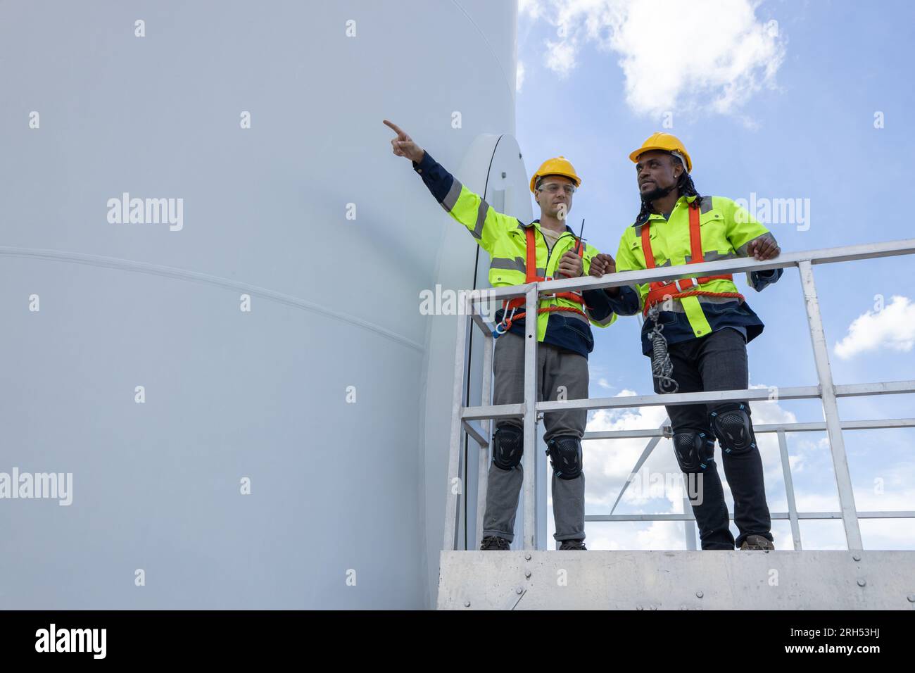 Techniker für Windturbinenanlagen, männliches Team, das für die Instandhaltung der Baustelle zuständig ist. Eco Power-Energieerzeuger für nachhaltige Menschen Stockfoto