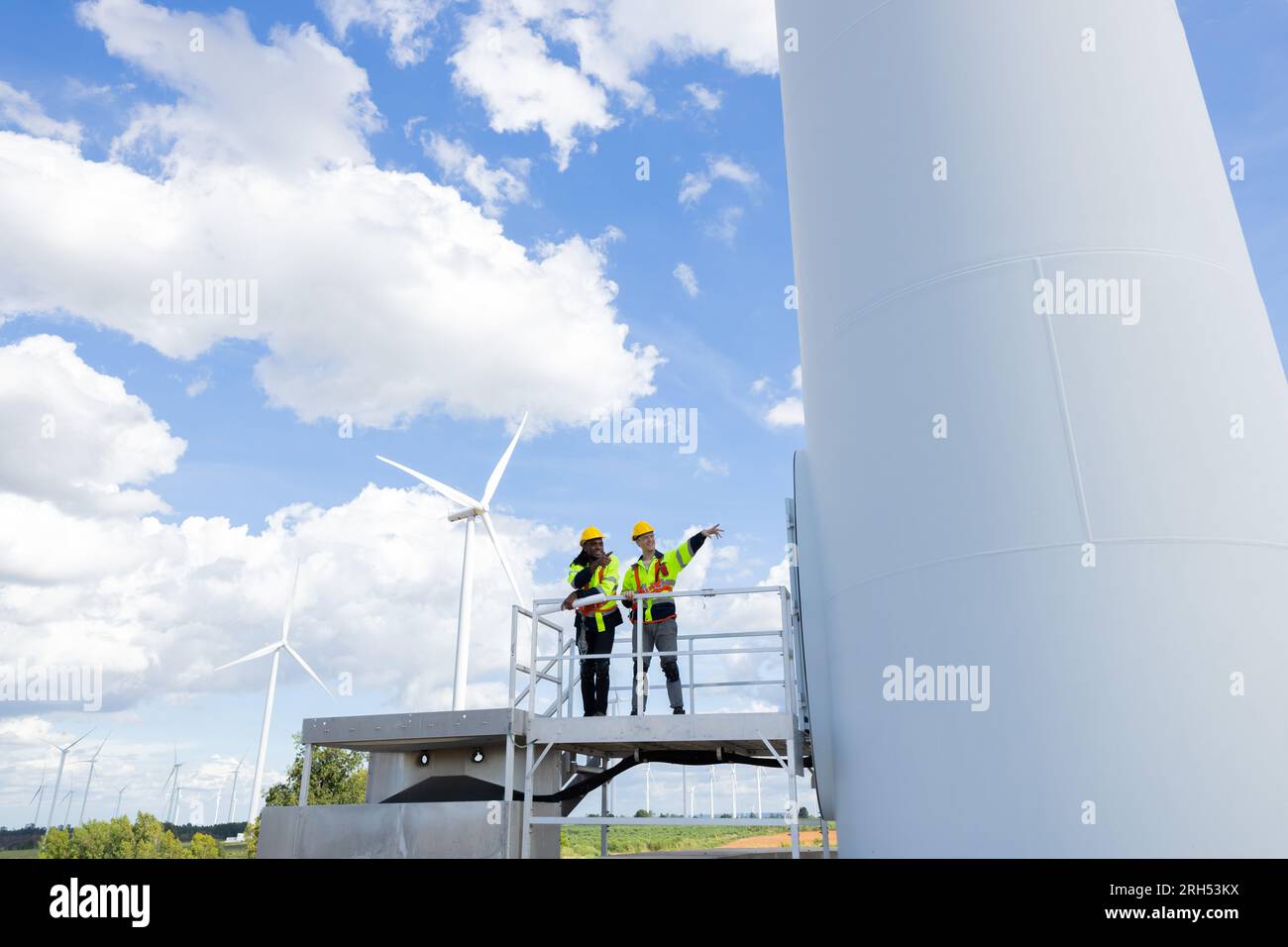 Techniker für Windturbinenanlagen, männliches Team, das für die Instandhaltung der Baustelle zuständig ist. Eco Power-Energieerzeuger für nachhaltige Menschen Stockfoto