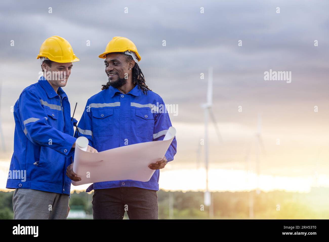 Ingenieur-Team-Außendienst, der zusammen mit dem Grundriss für den Bau weiterer sauberer Stromerzeuger für Windturbinen untersucht Stockfoto