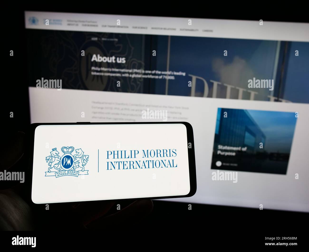 Person, die ein Smartphone mit dem Logo des US-Unternehmens Philip Morris International Inc. Auf dem Bildschirm vor der Website hält. Konzentrieren Sie sich auf das Display des Telefons. Stockfoto