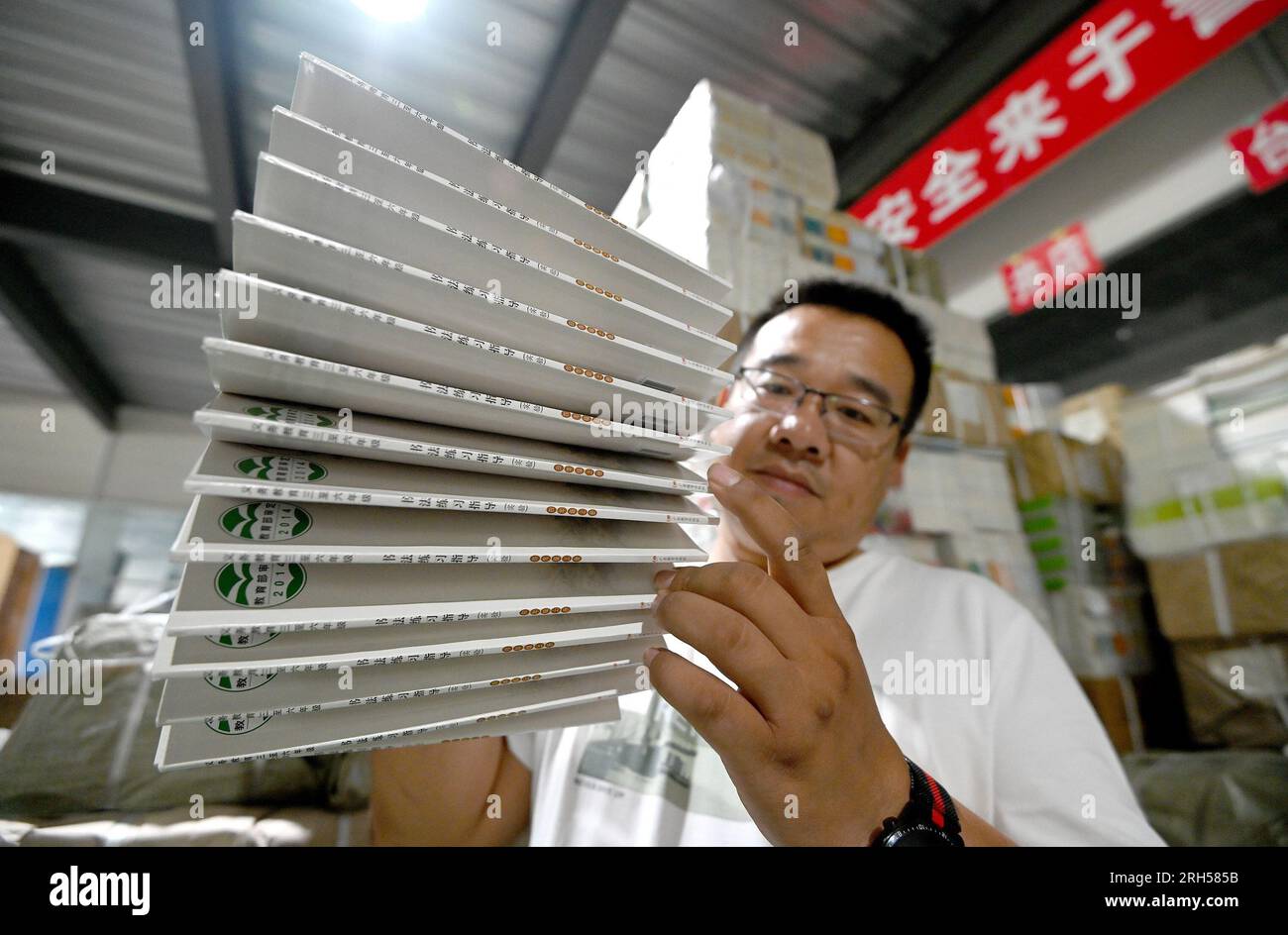 HANDAN, CHINA - 14. AUGUST 2023 - Ein Mitarbeiter der Buchhandlung Xinhua zählt Lehrbücher für das neue Semester an der Grund- und Mittelschule in Handan, He Stockfoto