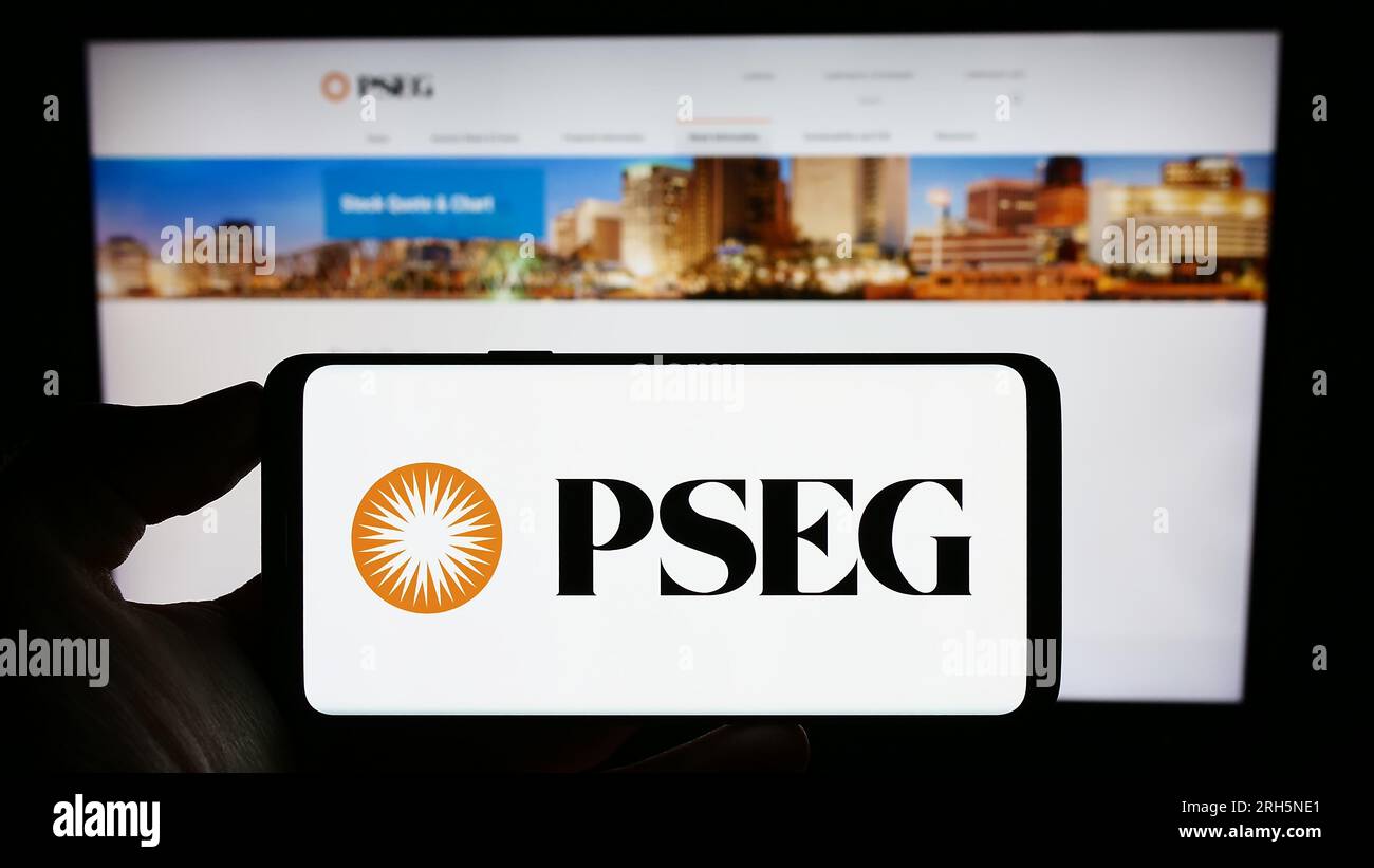 Person, die ein Mobiltelefon mit dem Logo der US-amerikanischen Public Service Enterprise Group (PSEG) auf dem Bildschirm vor der Webseite hält. Konzentrieren Sie sich auf das Display des Telefons. Stockfoto