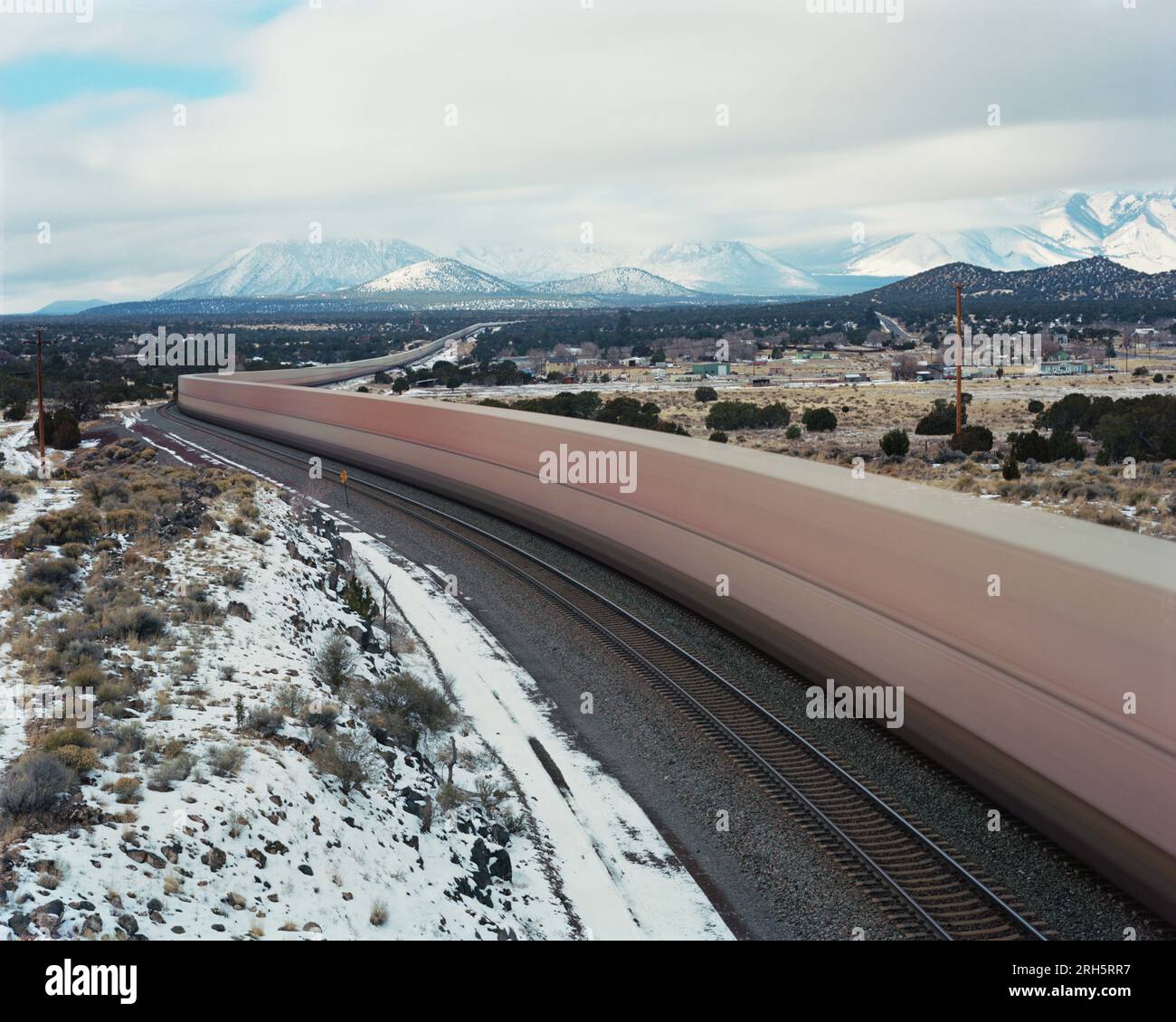 Ein Zug verschwimmt durch eine Winterlandschaft Stockfoto