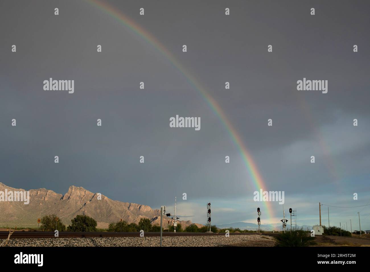 Regenbogen über Bahngleisen bei launischem Wetter Stockfoto