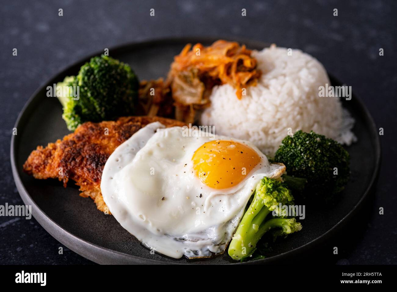 Koreanisches Brathähnchen mit Kimchi, Brokkoli und Ei Stockfoto