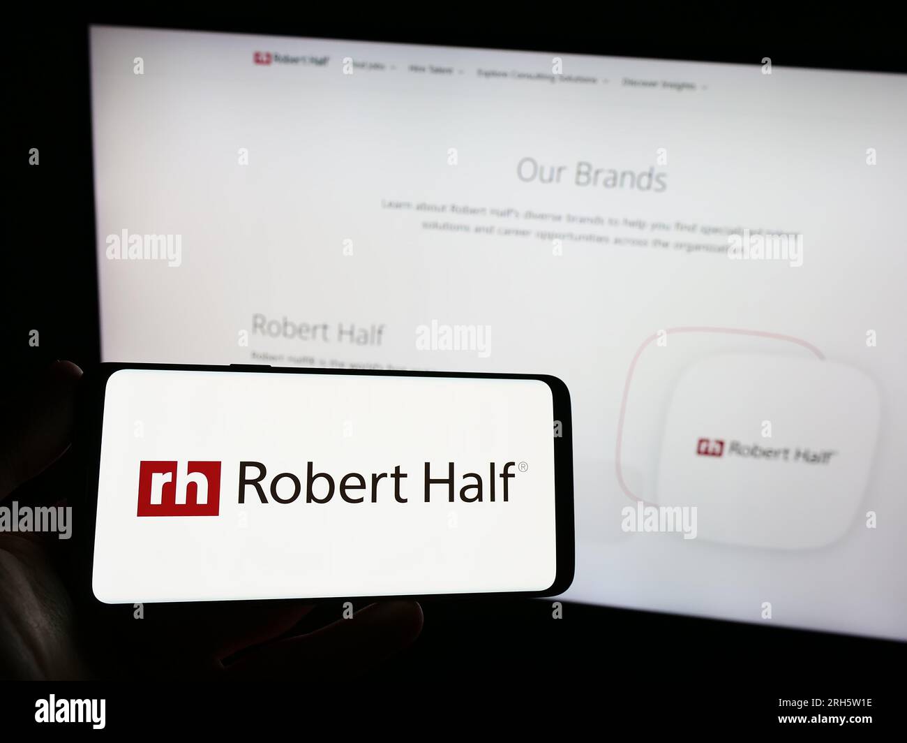 Person, die ein Smartphone mit dem Logo des US-Unternehmens Robert Half International Inc. Auf dem Bildschirm vor der Website hält. Konzentrieren Sie sich auf das Display des Telefons. Stockfoto