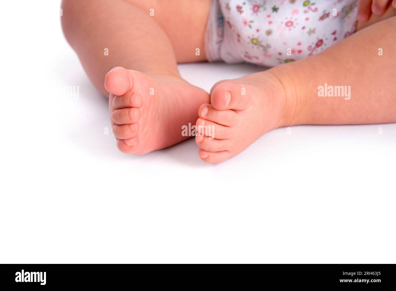 Zwei kleine Babyfüße nähern sich auf weißem Hintergrund Stockfoto