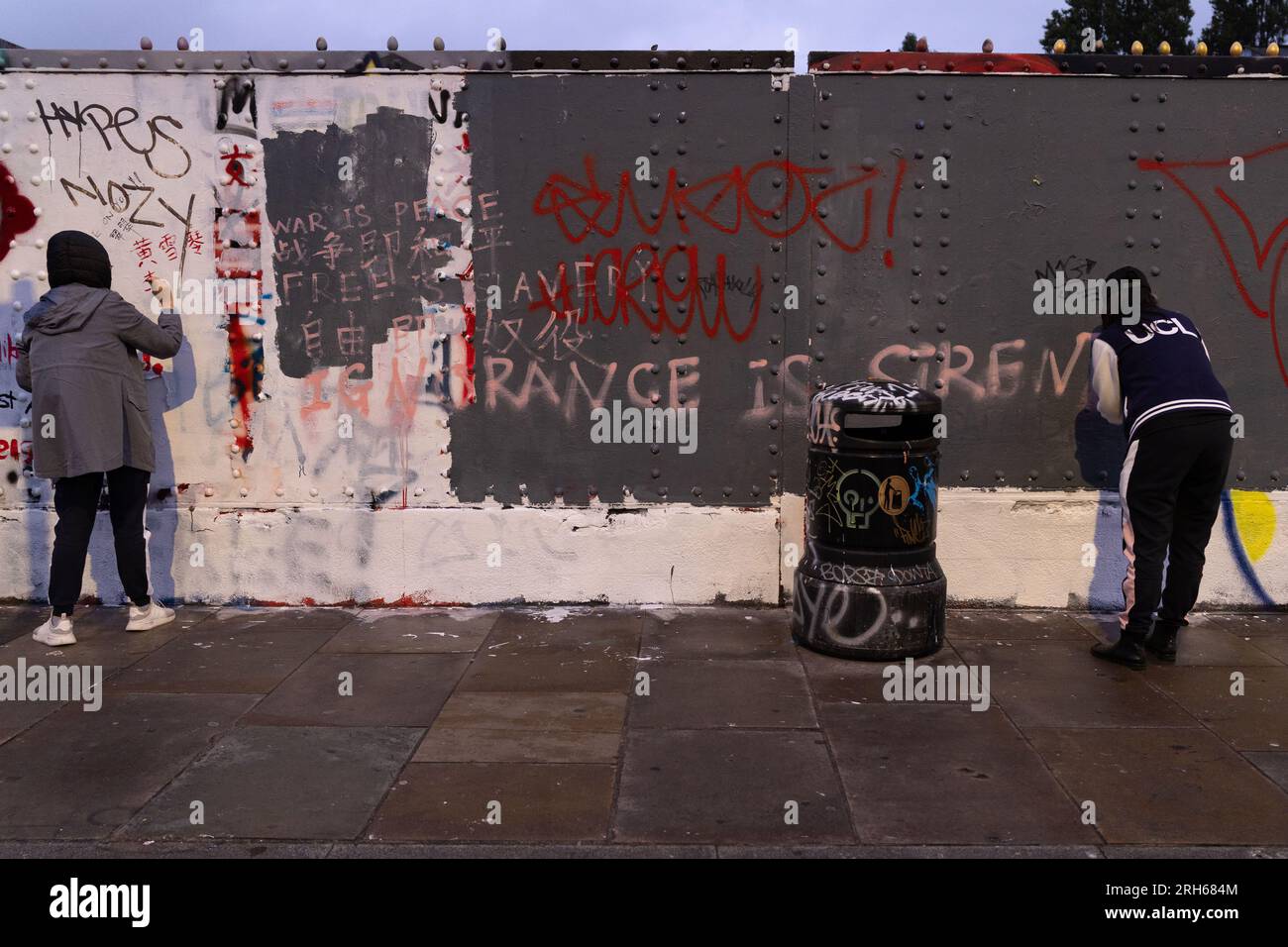 Aktivisten von Wearechainwoman malen Anti-Peking-Gegenbotschaft in Brick Lane. Brick Lane in East London, historisch gefeiert für seine vielseitige Straßenkunst, wurde kürzlich in einen umstrittenen Graffiti-Krieg verwickelt. Der Konflikt begann am Samstag, den 5., als eine Gruppe von Künstlern die '12 sozialistischen Grundwerte' der Kommunistischen Partei Chinas präsentierte. In 24 fettgedruckte rote chinesische Schriftzeichen auf einer 100m-mm-Wand. Diese Werte sind "Wohlstand", "Demokratie", "Höflichkeit" und "Harmonie"; die sozialen Werte von "Freiheit", "Gleichheit", "Gerechtigkeit" und "Rechtsstaatlichkeit"; und die individuellen Werte von "Patriotismus", "TED" Stockfoto