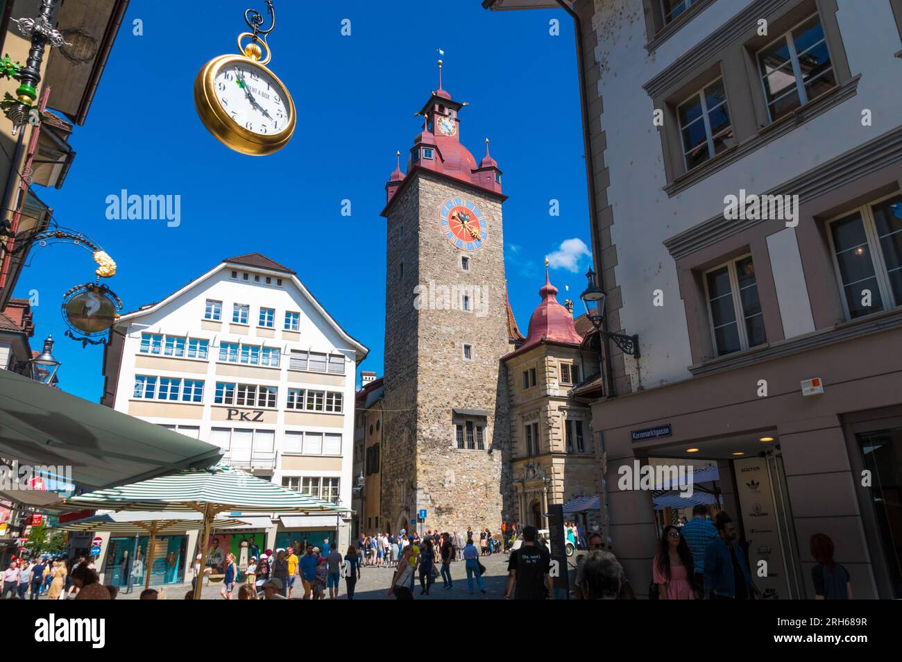 Wunderschöner Blick auf den Rathausturm auf dem geschäftigen Kornmarkt in der Altstadt von Luzern, Schweiz. Der Turm des Rathauses wurde errichtet... Stockfoto