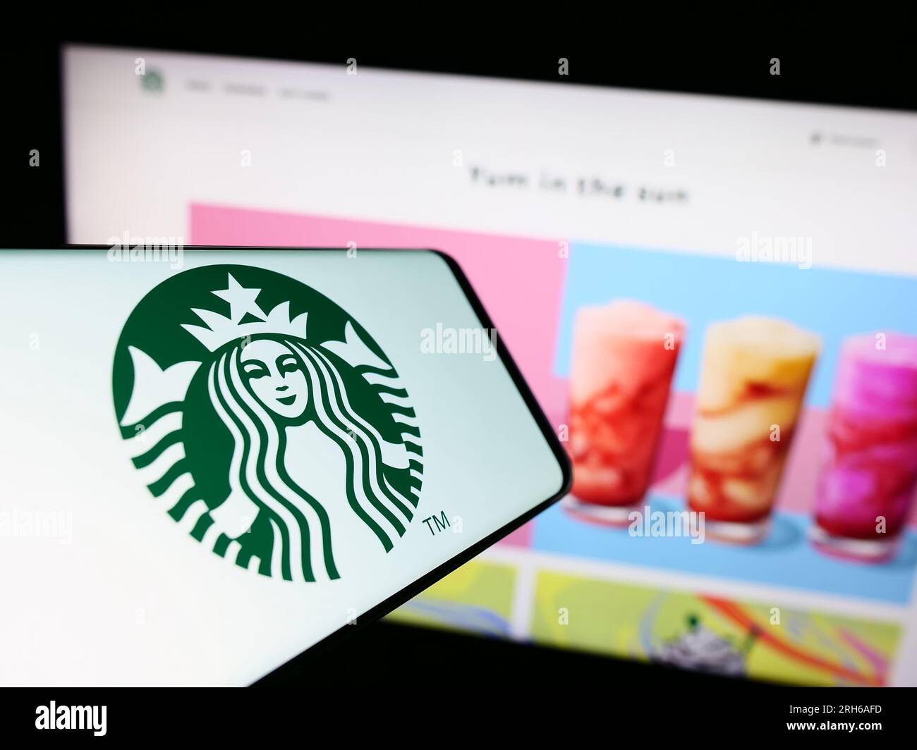 Smartphone mit Logo des amerikanischen Kaffeehausunternehmens Starbucks Corporation auf dem Bildschirm vor der Website. Fokus auf die Mitte rechts des Telefondisplays. Stockfoto