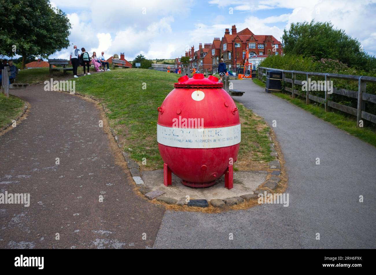 Rot-weiß bemalte Seemine als Sammelbox in Robin Hood's Bay Stockfoto