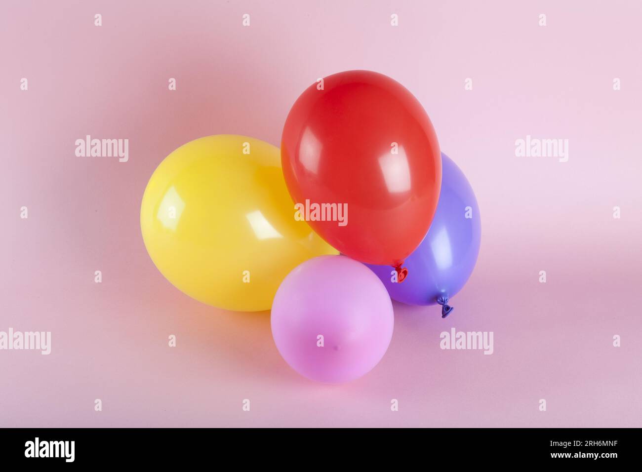 Ballons in harmonischen Farben auf pinkfarbenem Hintergrund. Fotos mit minimalen Farbfotos. Stockfoto