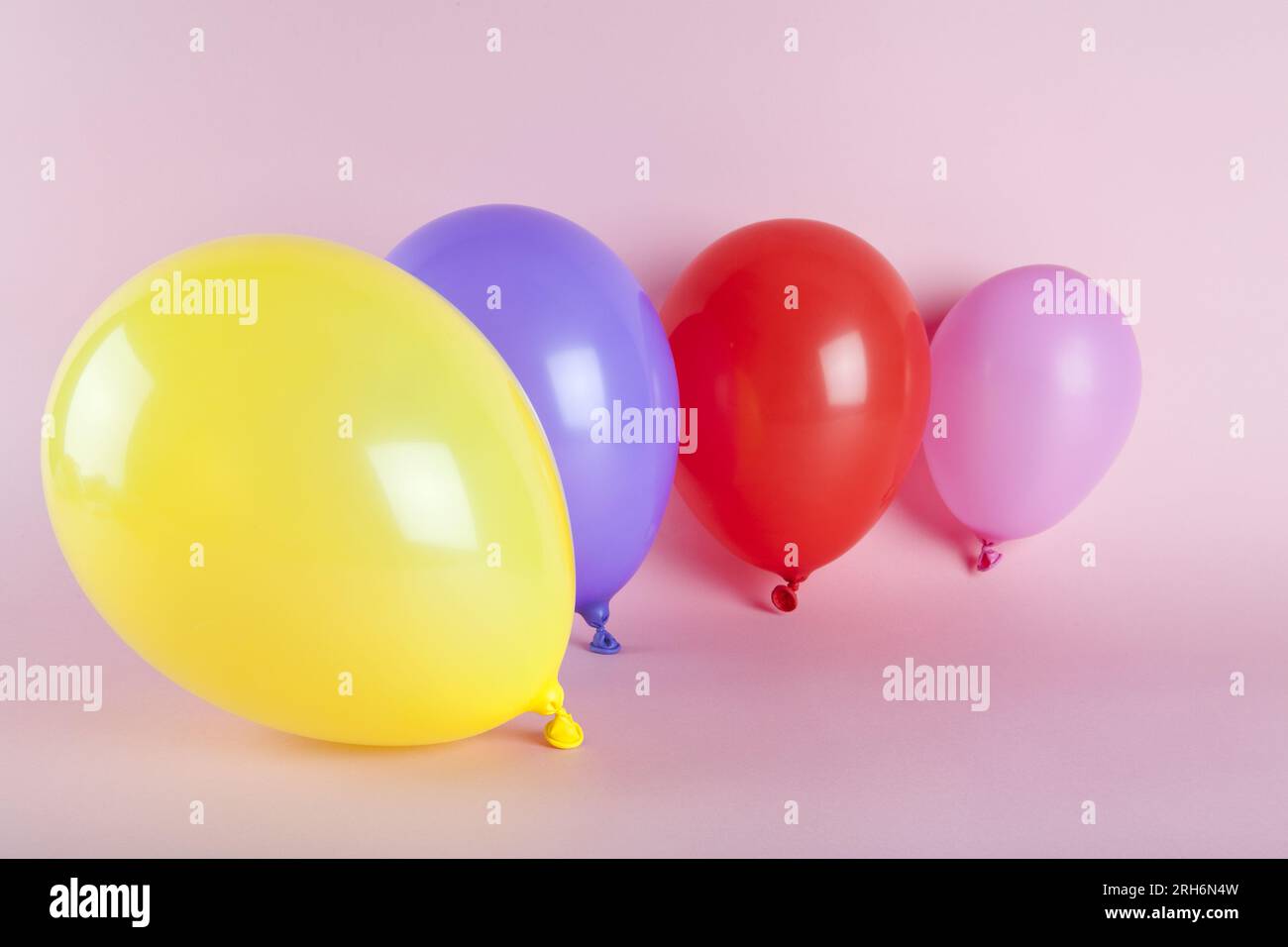 Ballons in harmonischen Farben auf pinkfarbenem Hintergrund. Fotos mit minimalen Farbfotos. Stockfoto