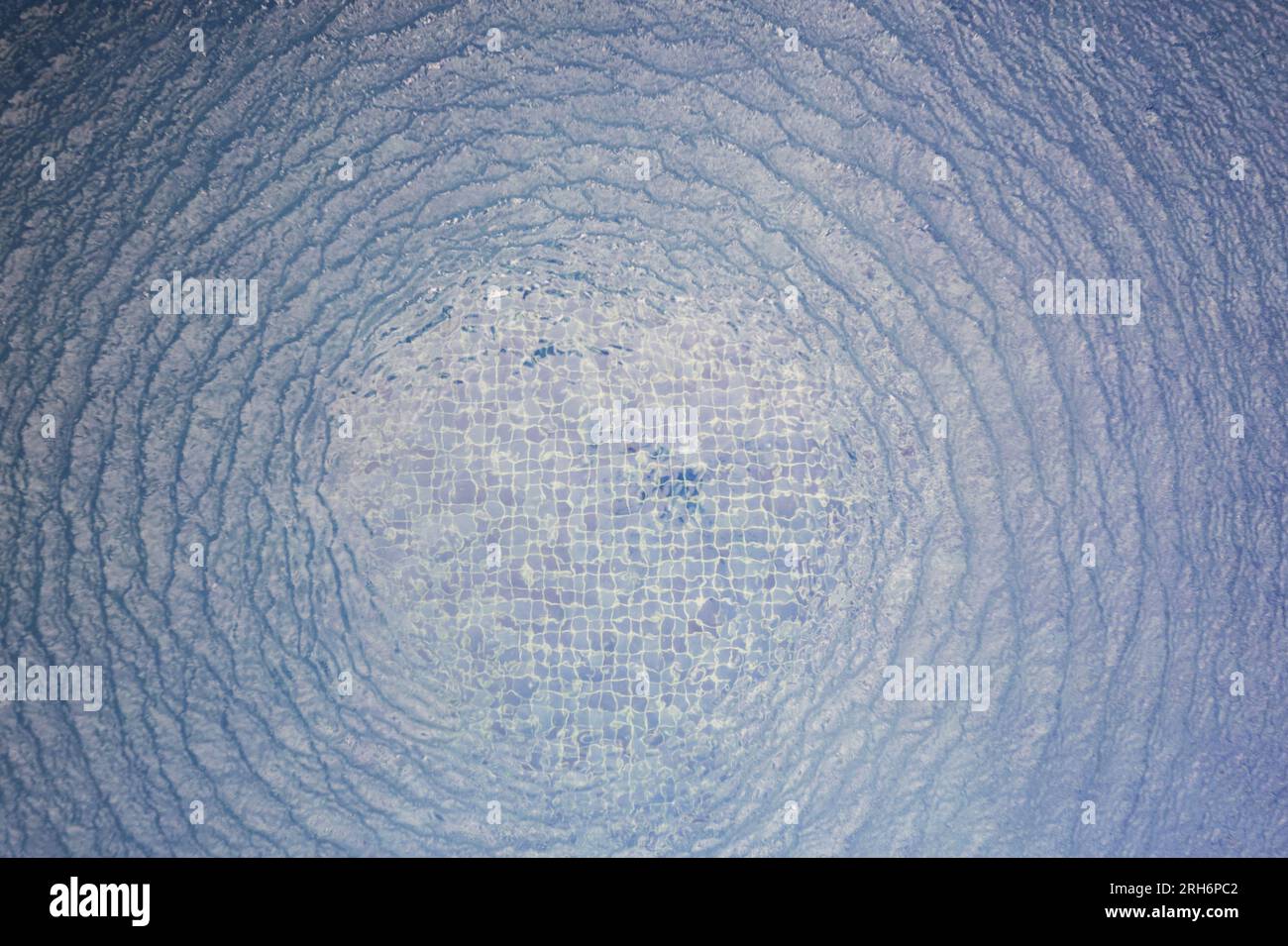 Blauer Wasserhintergrund mit kreisförmigen Wellen über der Draufsicht Stockfoto