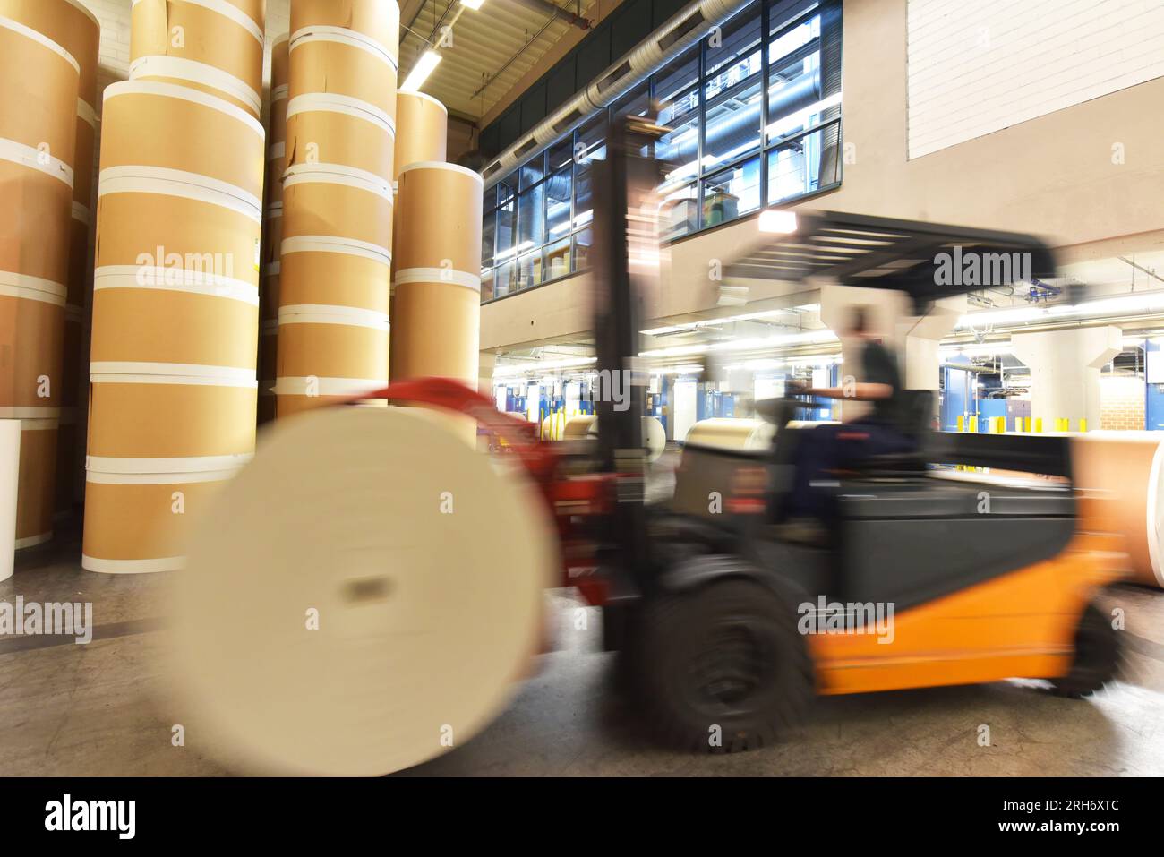 Lagerung von Papierrollen in einer großen Druckerei - Transport mit einem Gabelstapler Stockfoto