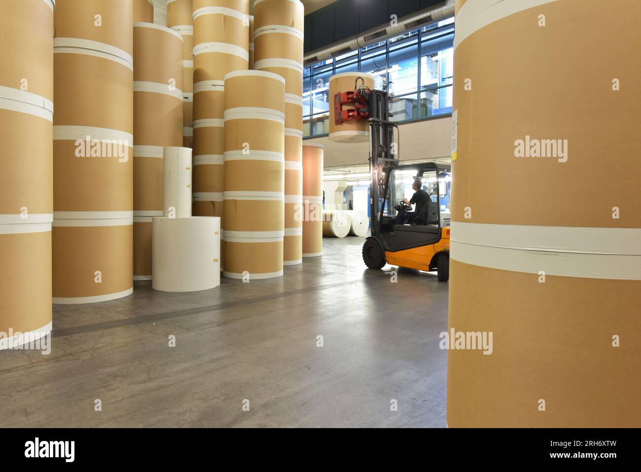 Lagerung von Papierrollen in einer großen Druckerei - Transport mit einem Gabelstapler Stockfoto