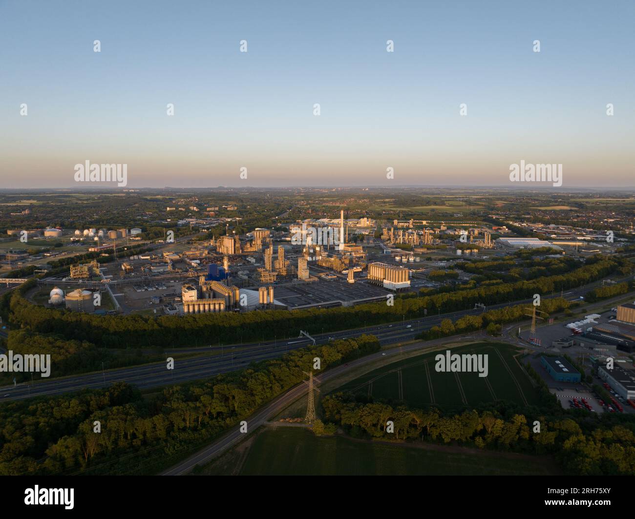 Luftaufnahme des Chemie-Industrieparks Geleen mit einem großen Kühlturm bei Sonnenuntergang. Stockfoto