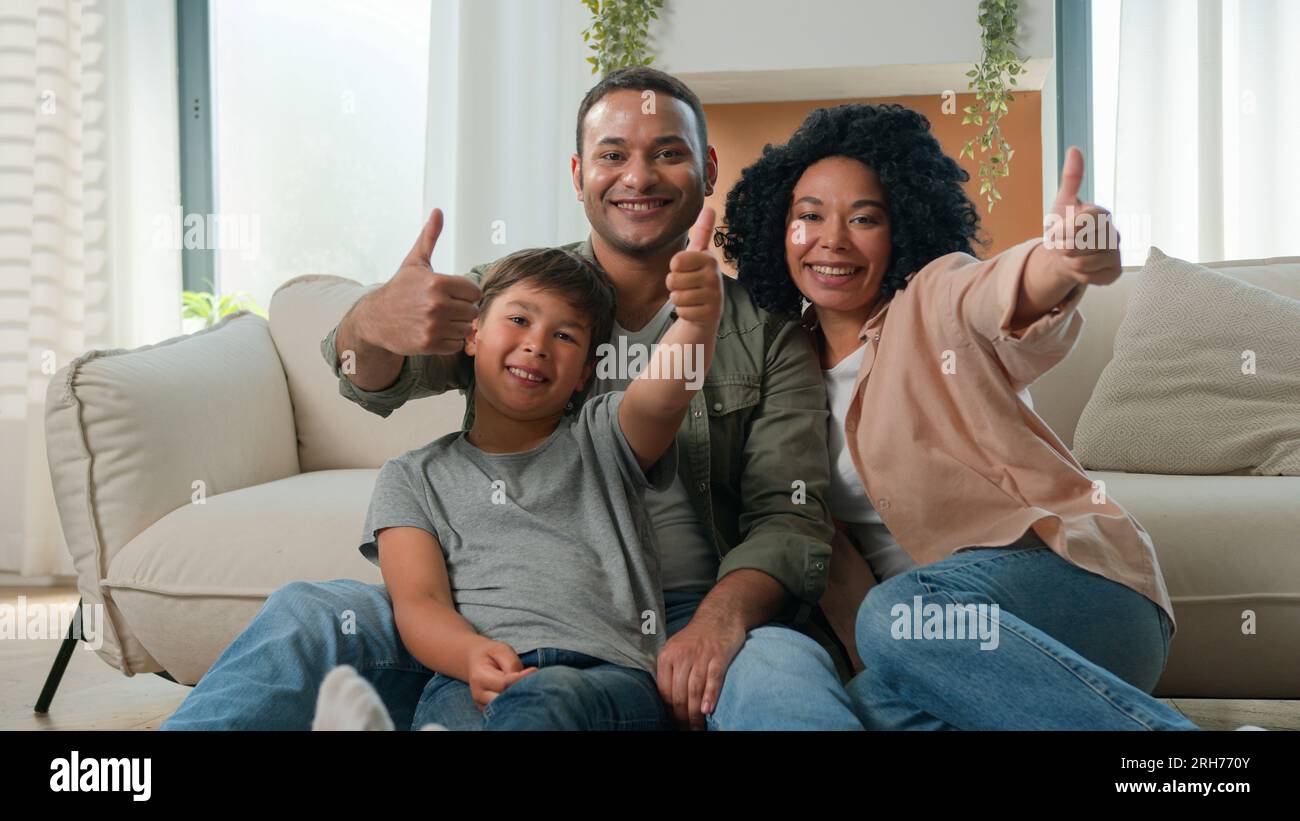 Frohe multirassische Familie afroamerikanische Eltern umarmen sich mit dem kaukasischen kleinen Jungen Sohn Adoptivkind auf der Etage reden Spaß Spaß Wochenende lächeln Stockfoto