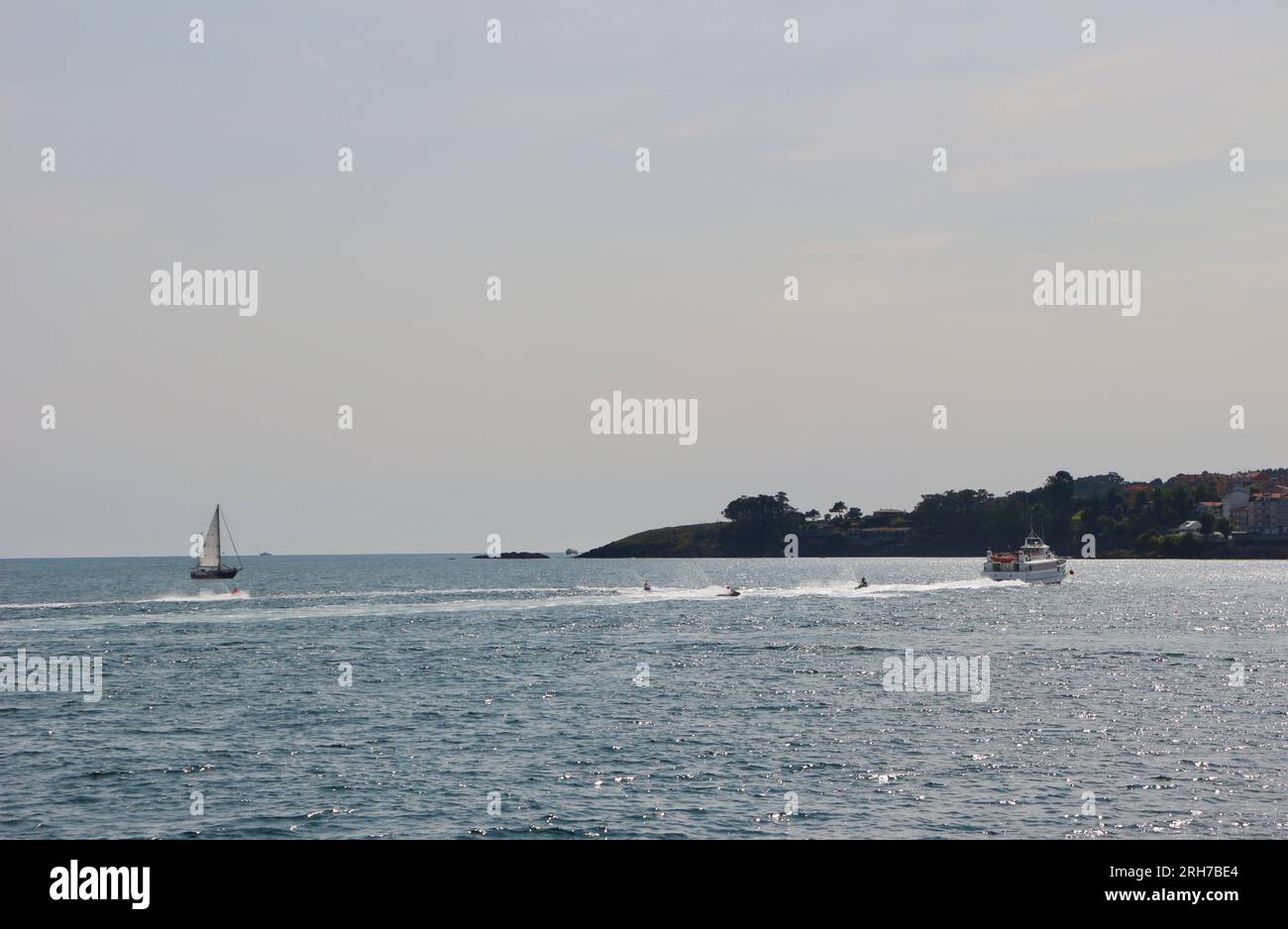 Eine kleine Fähre mit Jetskis folgt vor der Nordküste nahe der Küste Sangenjo Sanxenxo Pontevedra Galicien Spanien Stockfoto