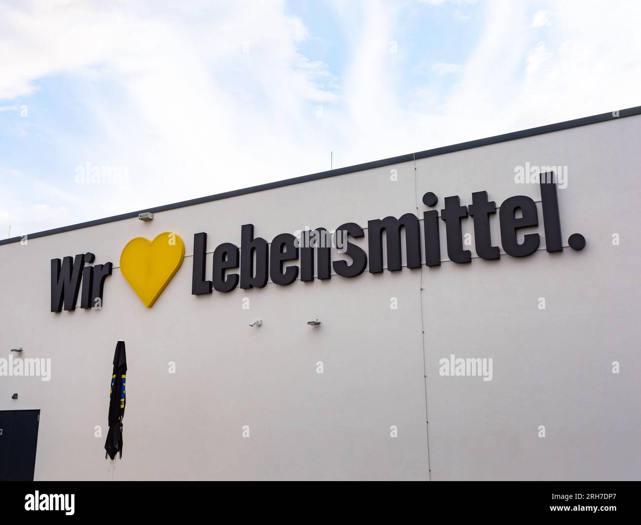 „Wir lieben Lebensmittel“-Slogan an der Fassade eines Edeka-Supermarktes. Werbung auf dem Gebäude des deutschen Lebensmittelgeschäfts. Stockfoto