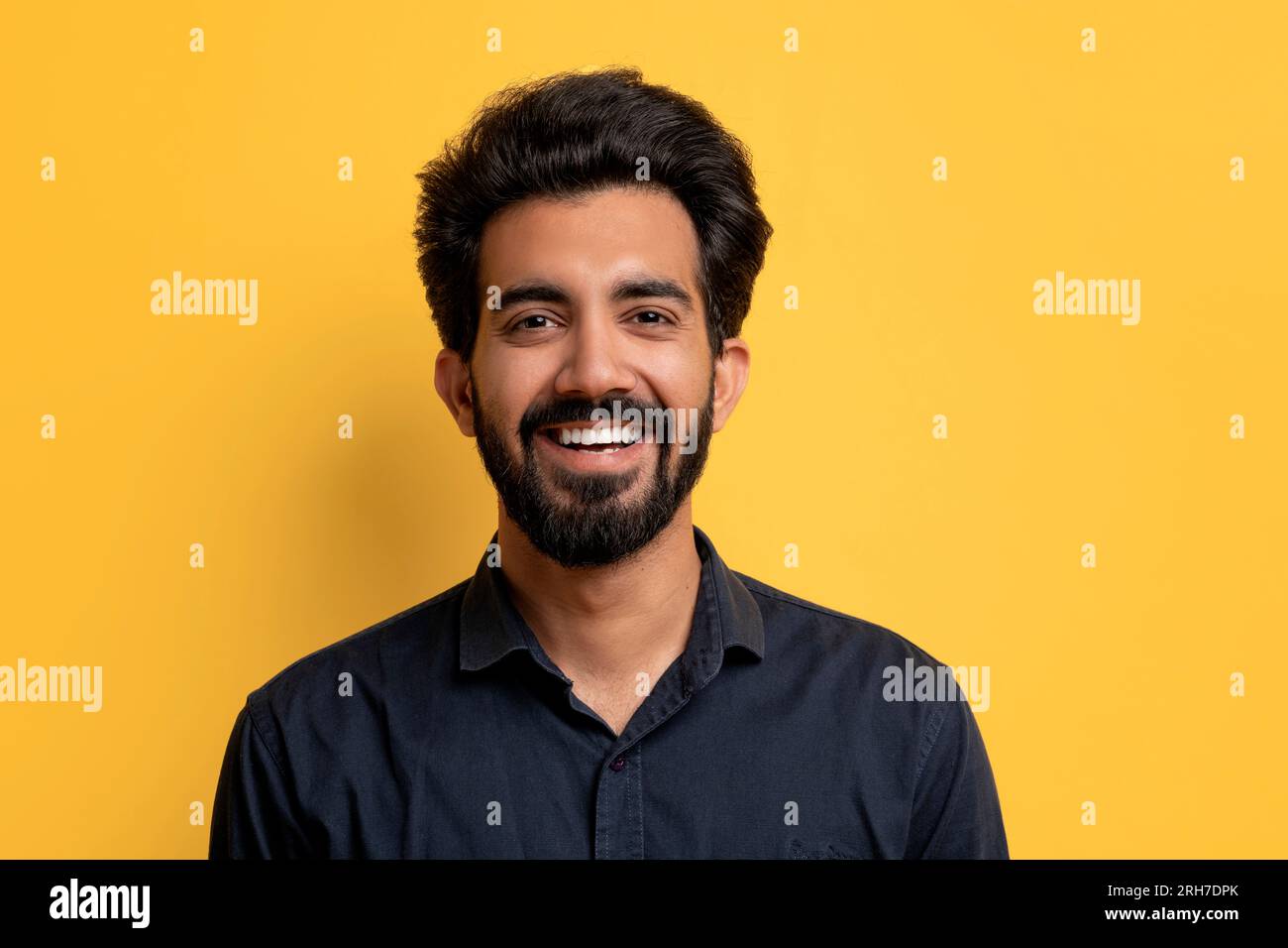 Porträt eines gutaussehenden, lächelnden indianers, der auf gelbem Studiohintergrund posiert Stockfoto