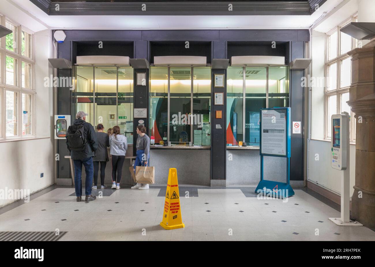 Warteschlange am Ticketschalter des Bahnhofs Lancaster mit einem Fahrgast, der ein Ticket kauft Stockfoto