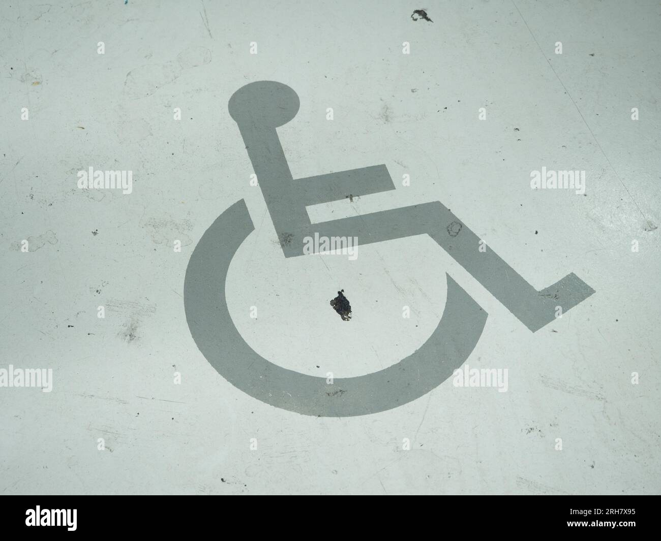 Ein Rollstuhlsymbol ist auf der Straße gemalt. Es ist ein Parkplatz für Behinderte. Stockfoto