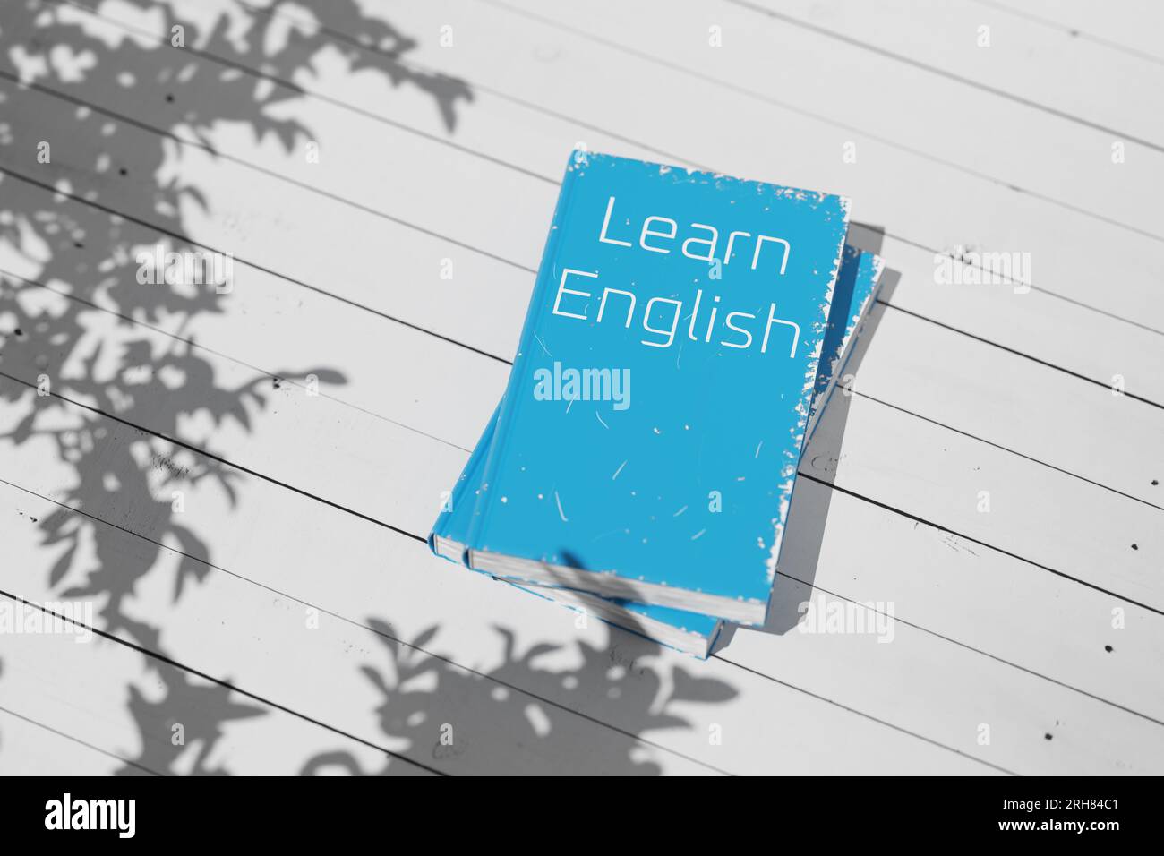 Englisches Lehrbuch auf einem weißen Holztisch. Englisch lernen. Englische Grammatik. Englischsprachiges Lehrbuch zum Sprachenlernen. 3D-Rendering. Stockfoto