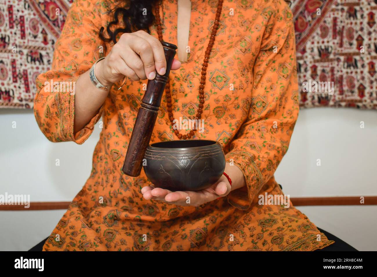 Eine Frau, die Meditation und Heilung mit einer tibetischen Gesangsschale praktiziert. Stockfoto