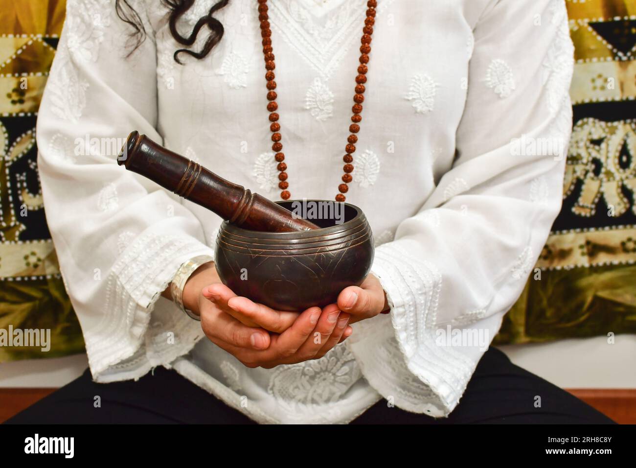 Eine Nahaufnahme einer Frauenhände mit einer tibetischen Klangschale. Stockfoto