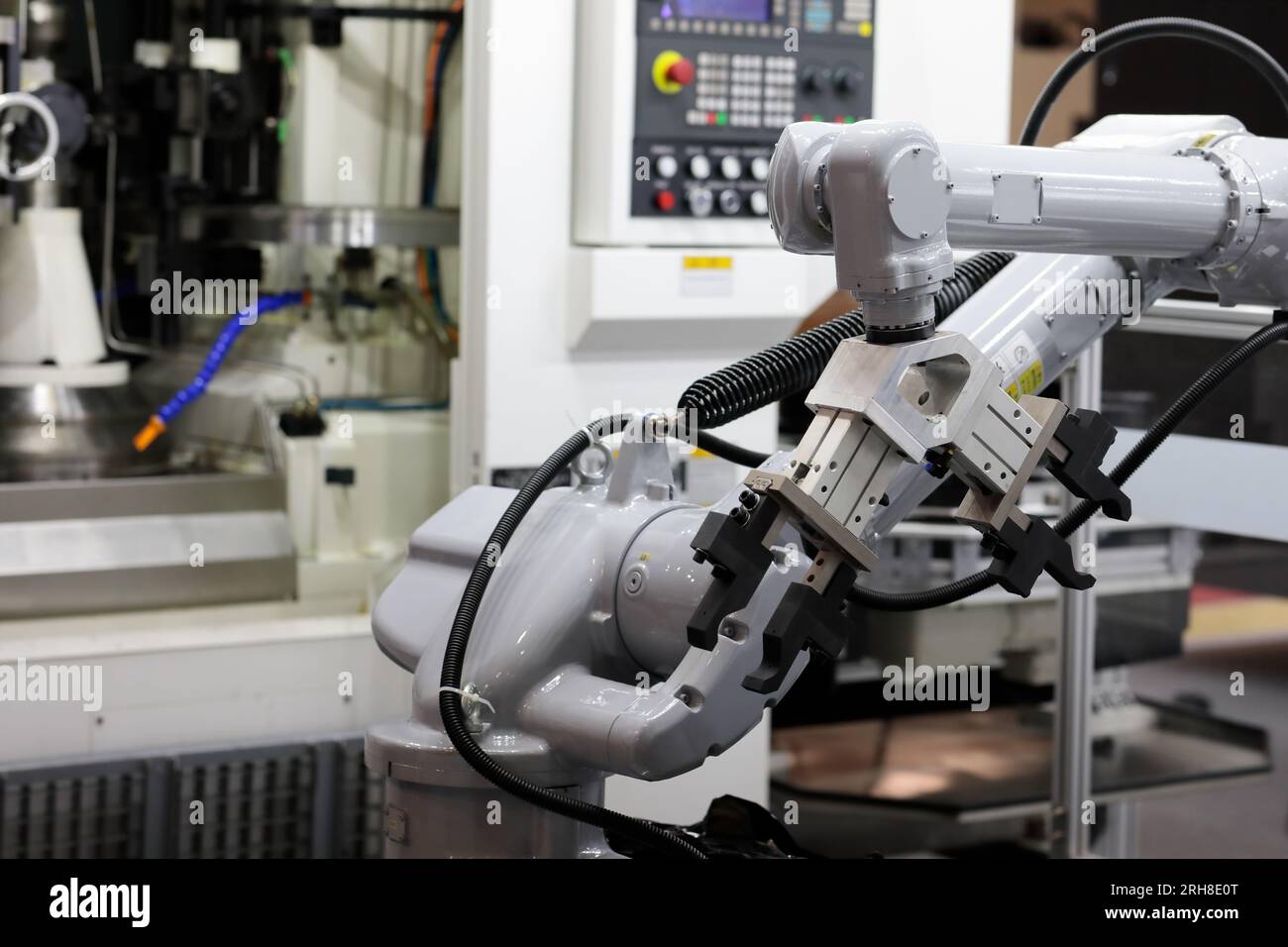 Industrie-Roboterarm mit CNC-Bearbeitungszentrum. Automatisierte Roboterzelle. Selektiver Fokus. Stockfoto