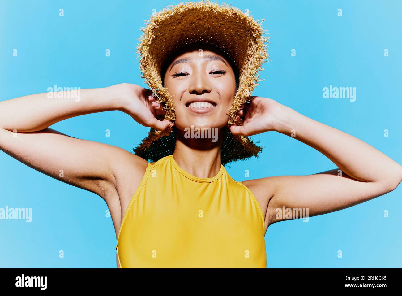 Gelber Badeanzug Porträt Schönheit Lächeln trendige Sommerhut Mode jung Stockfoto