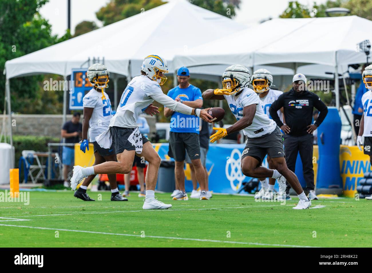 Los Angeles Chargers Quarterback Justin Herbert (10) übergibt den Ball an Running Back Joshua Kelly (25) während des Trainingslagers im Jack Hammett Sports Complex, Montag, 14. August 2023, in Costa Mesa, Calif. (Louis Chen/Image of Sport) Stockfoto